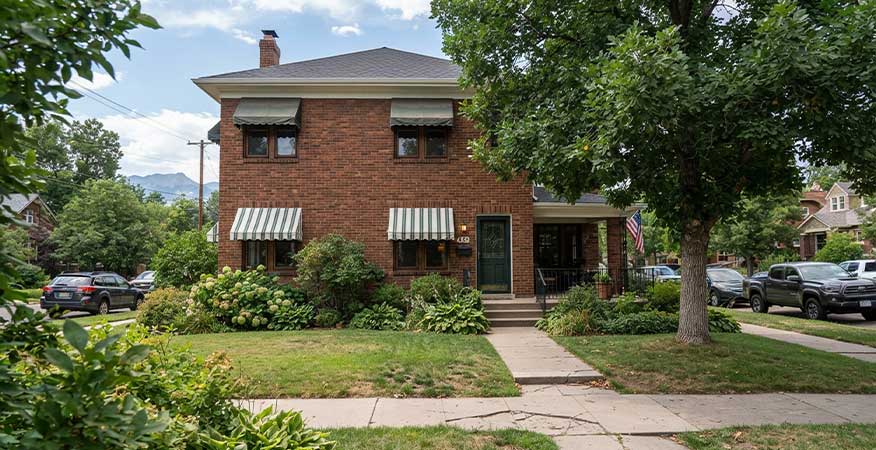 window awnings on brick Denver home exterior