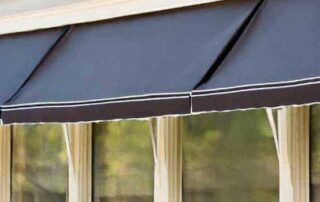 Stylish black outdoor window awning with white trim, enhancing home aesthetics and providing shade. Suitable for various home types.
