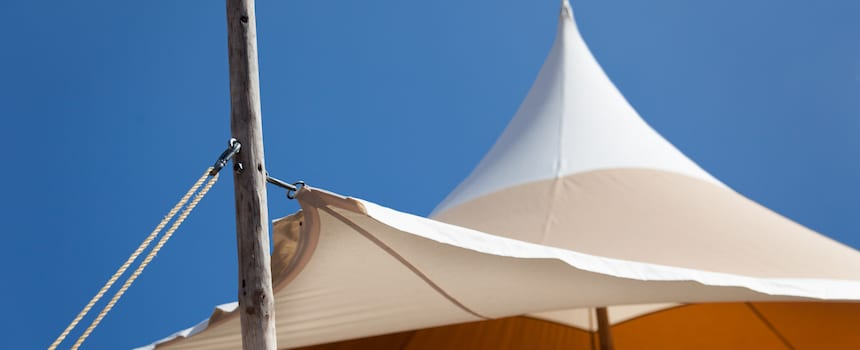 Is Your Awning Ready for Summer White canopy tent and wooden pole against blue sky