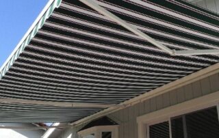A stylish striped awning installed over the windows of a house exterior, adding both shade and curb appeal. This practical home upgrade showcases a smart way to invest a tax return, enhancing comfort and property value.