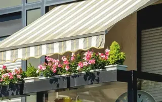 Striped awning over balcony with flowers