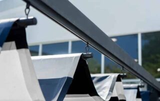 Outdoor patio awnings providing shade on a sunny day, enhancing comfort and protecting the space from harsh sunlight. This image highlights the importance of cleaning a fabric awning to maintain its appearance and durability.